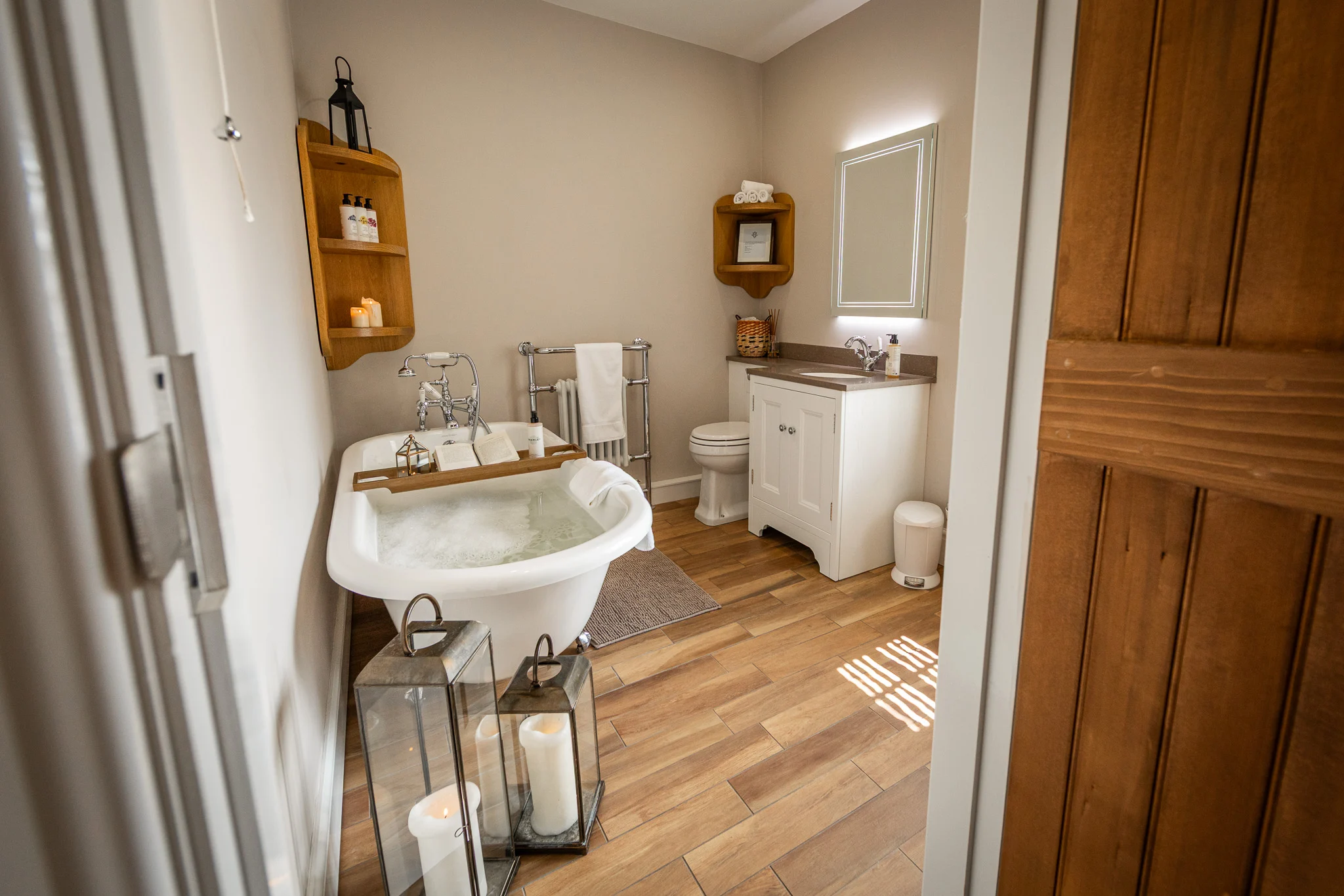 Bathroom at Pheasant Cottage, Peplow Hall Estate featuring a freestanding roll-top bath, soft lighting and elegant country house styling.