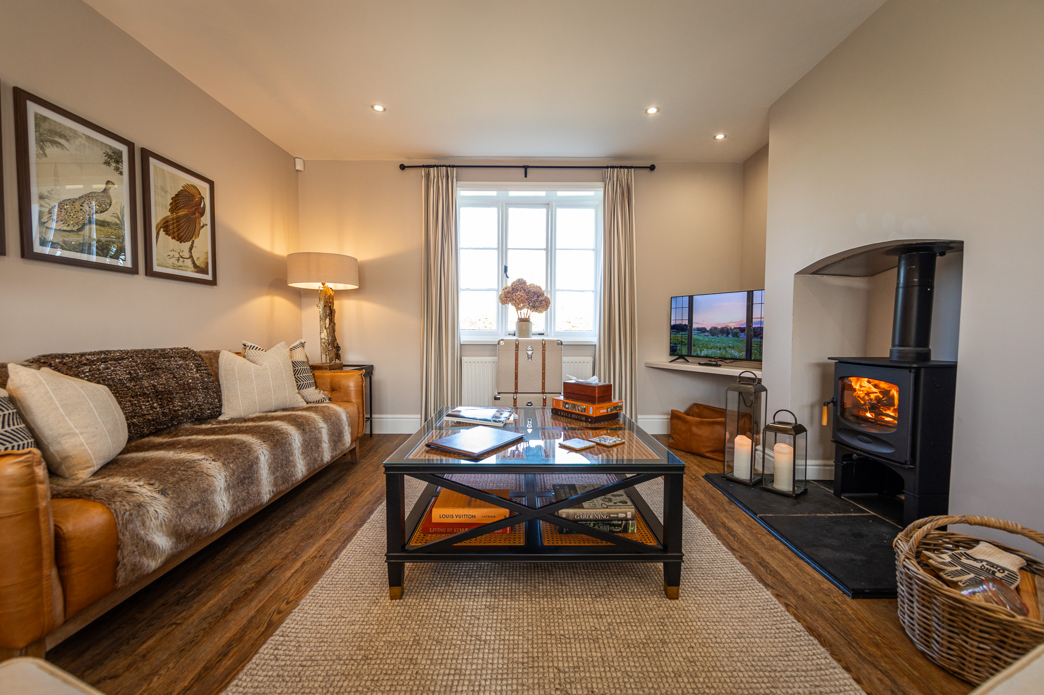 Pheasant Cottage Shropshire cottage living room with leather sofa, wood burning charnwood stove, coffee table and countryside views.