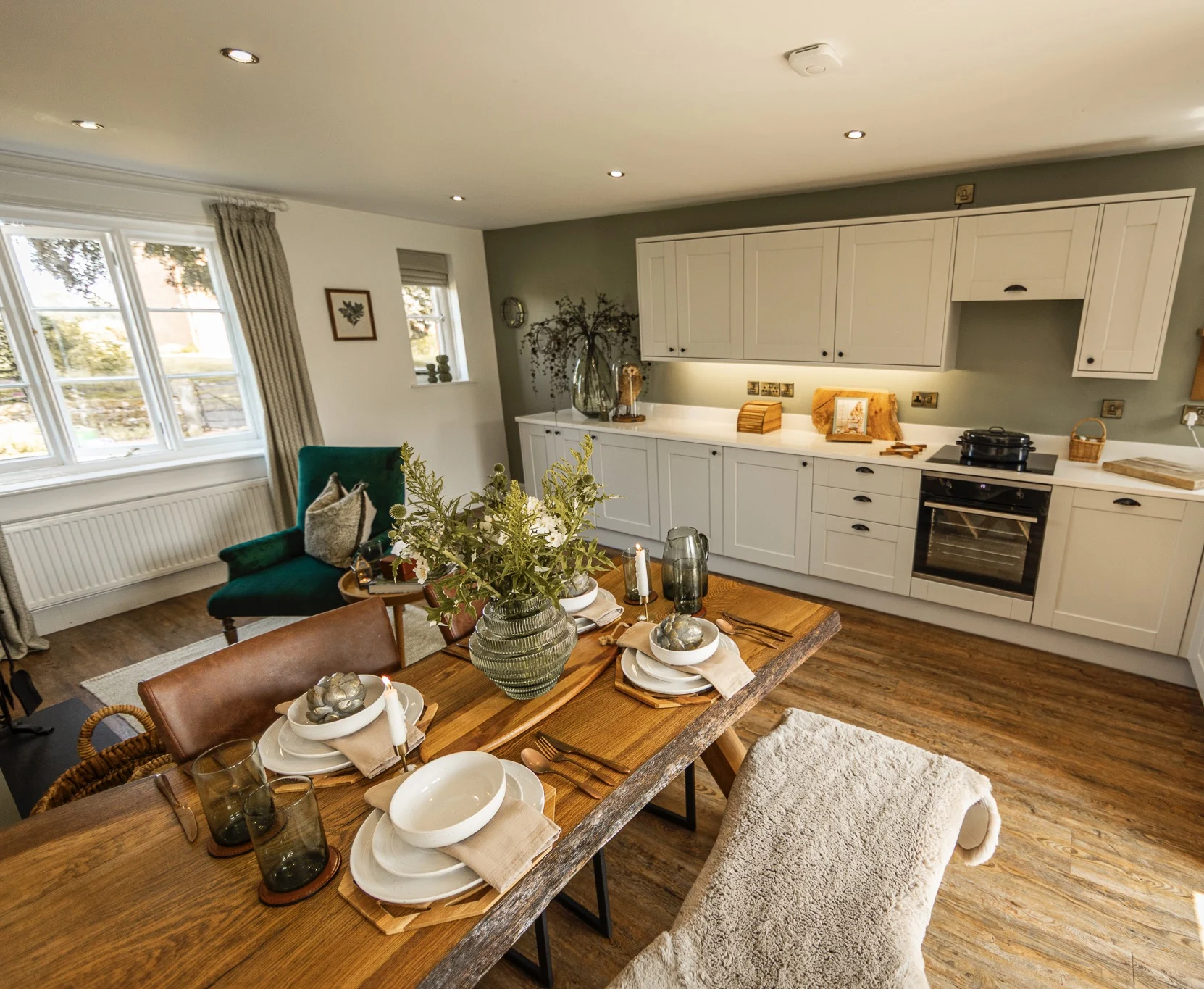Luxury open-plan kitchen and dining area at Owl Cottage, Peplow Hall Estate, Shropshire – stylish self-catering holiday accommodation with wooden dining table, shaker kitchen units and countryside views.
